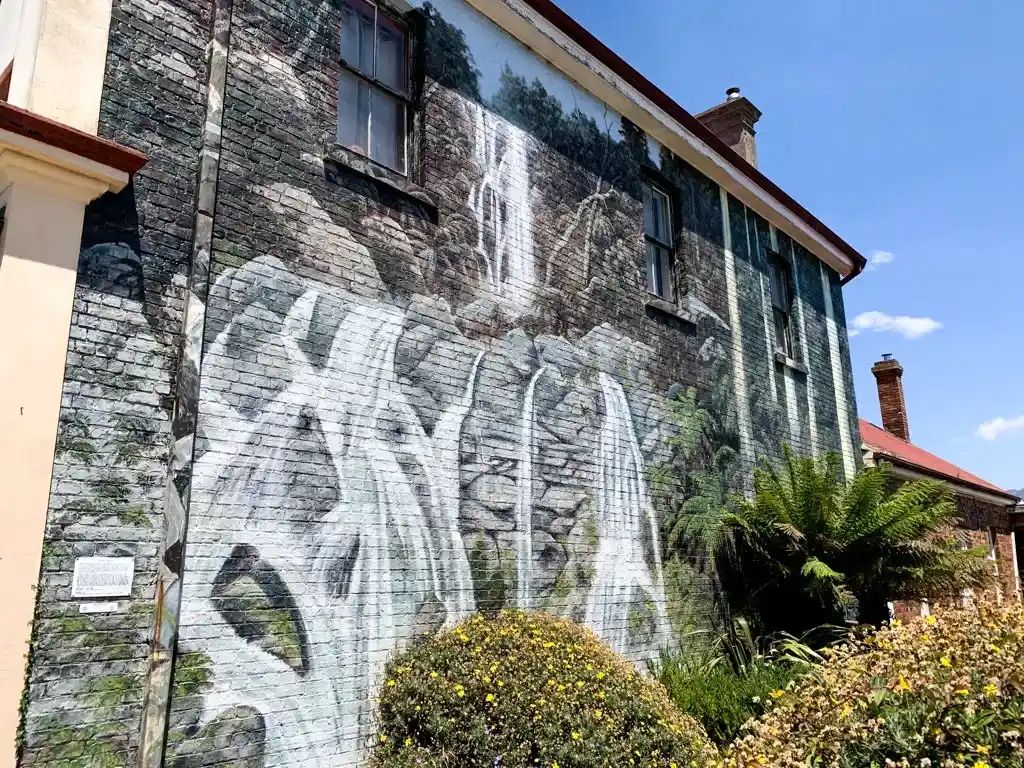 A mural of a waterfall painted on the side of the brick building in the small town of Sheffield, Tasmania