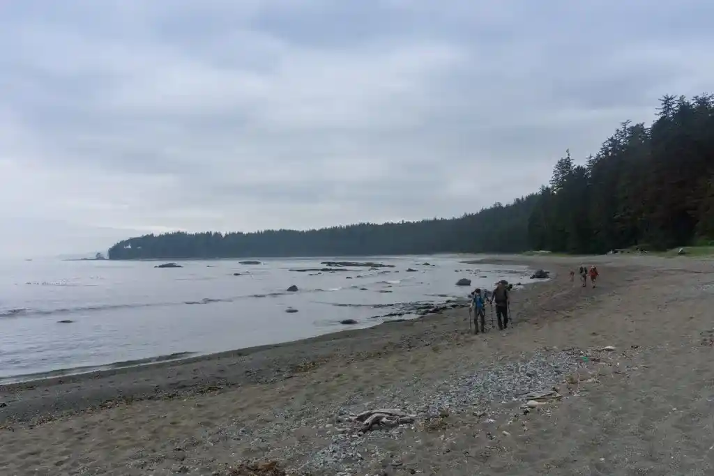 Hikers walk through soft sand near Carmanah River on the West Coast Trail