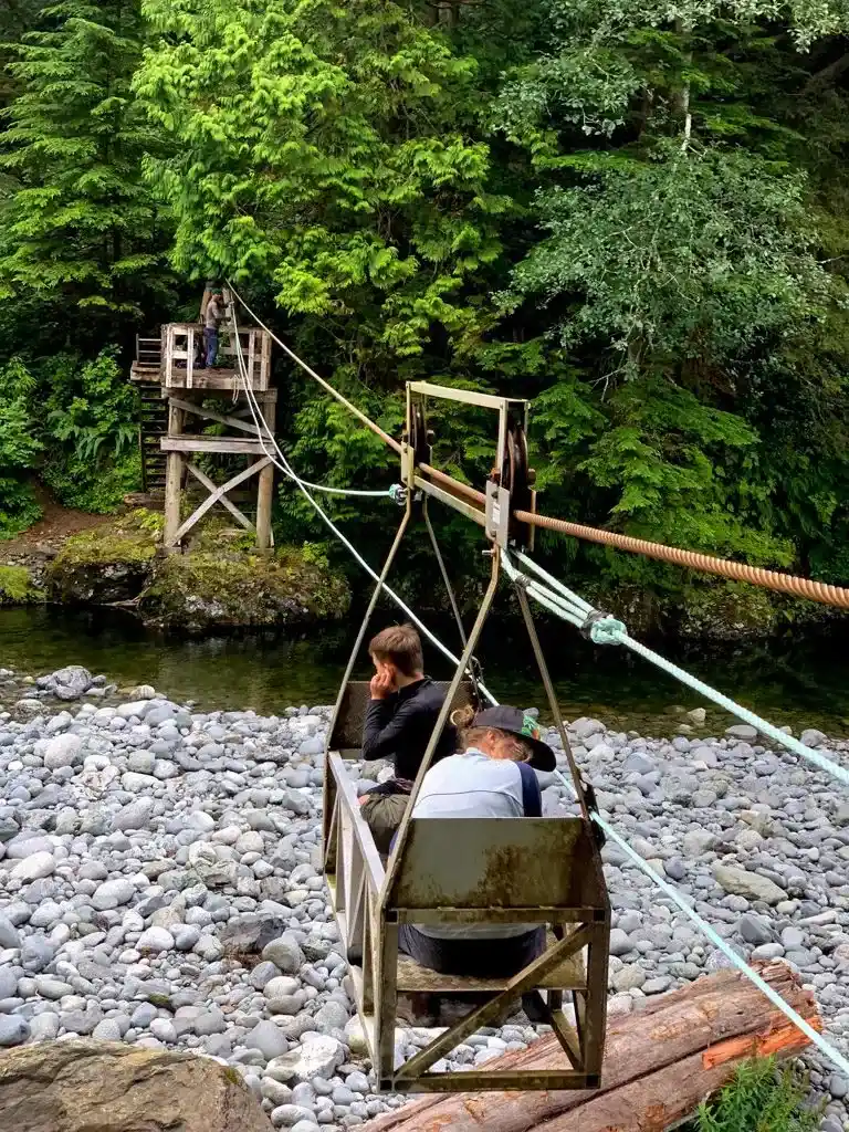 Two hikers ride the Camper Creek cable car on the West Coast Trail