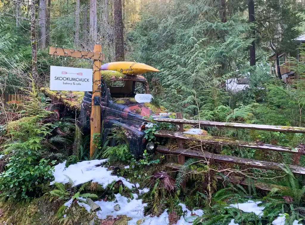 An old car at the sign to the Skookumchuck Bakery & Cafe in Egmont on the Sunshine Coast, BC