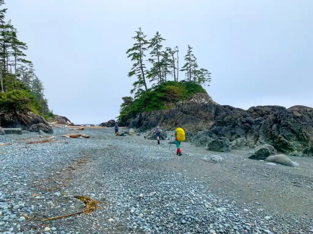 Hiking on a pocket beach on the North Coast Trail near Cape Sutil