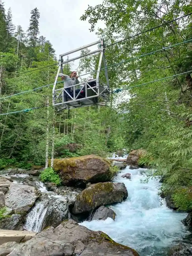 A hiker rides the cable car across Drinkwater Creek