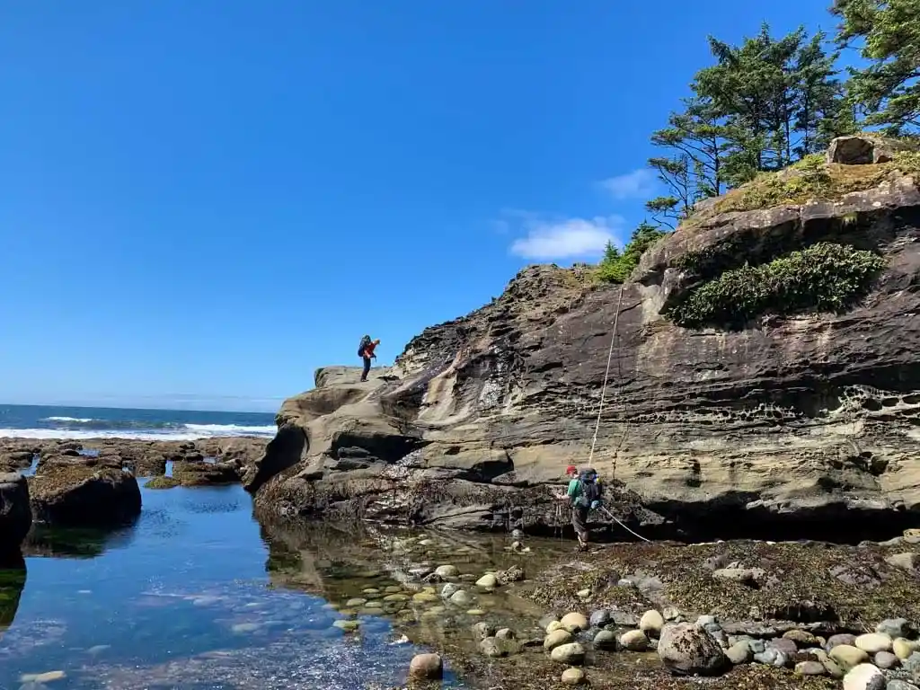Scrambling up a cliff on the Tatchu Trail