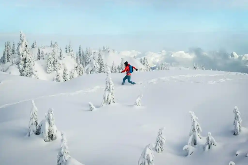 A woman in a red jacket snowshoes at Mount Seymour in Vancouver