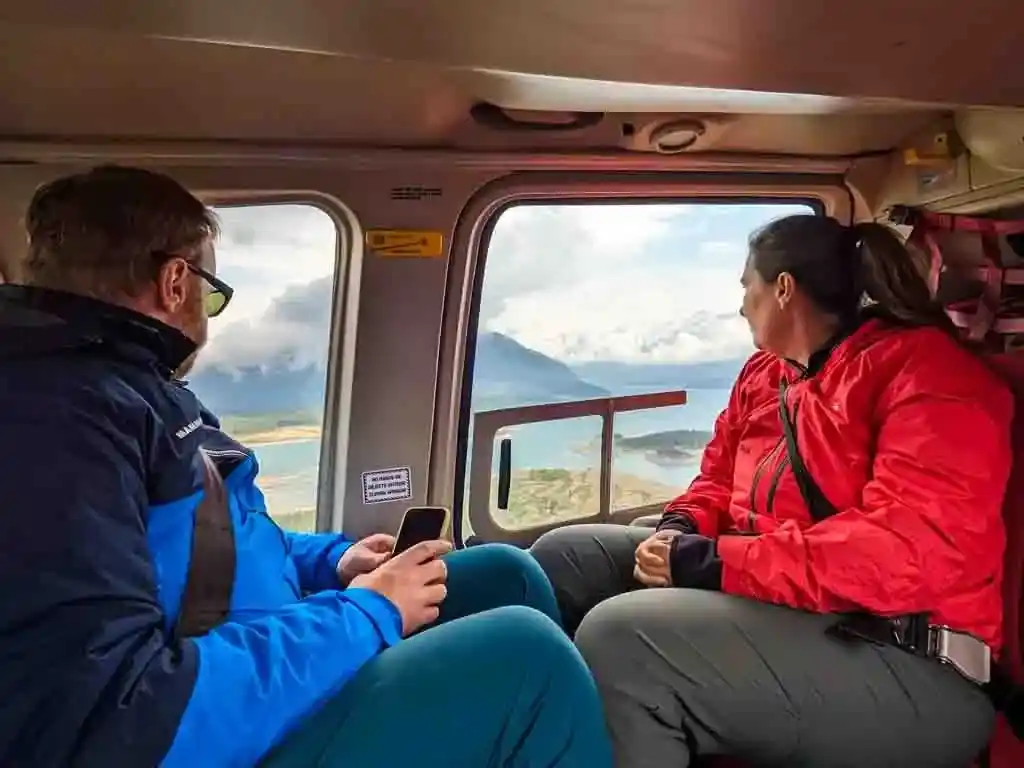 Two people look out the window of a helicopter on the flight to Mount Assiniboine