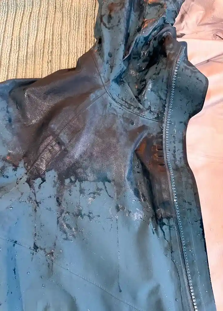 Close up of the shoulder of a rain jacket that is wetting out
