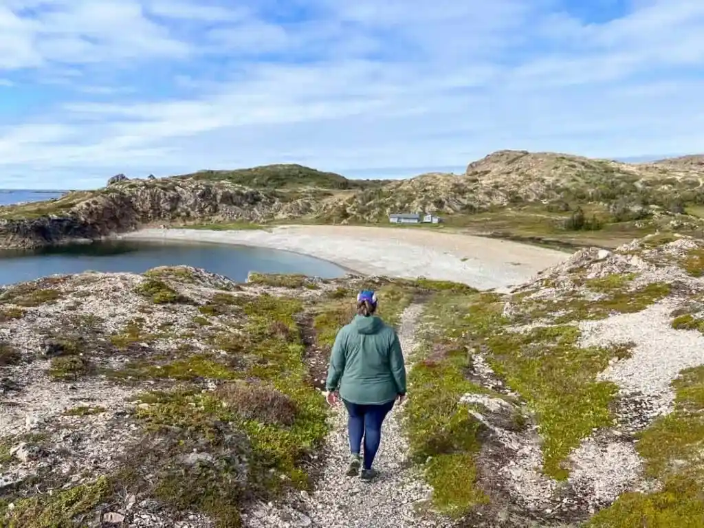 A woman walks along a trail near French Beach