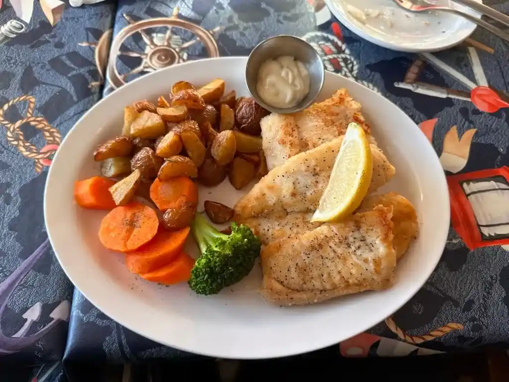 A plate of fish and vegetables at Seaside Restaurant in Trout River
